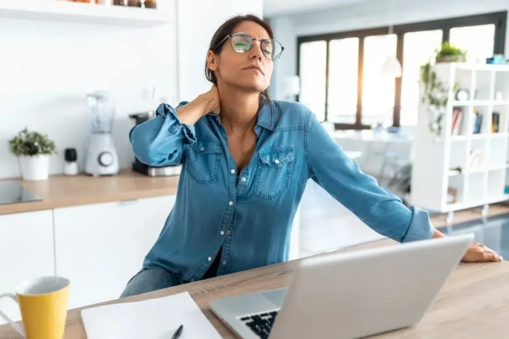 Woman holding on to the back of her neck in pain