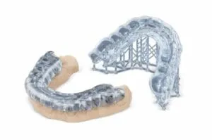 A 3D printed model of a lower jaw with a clear resin covering it