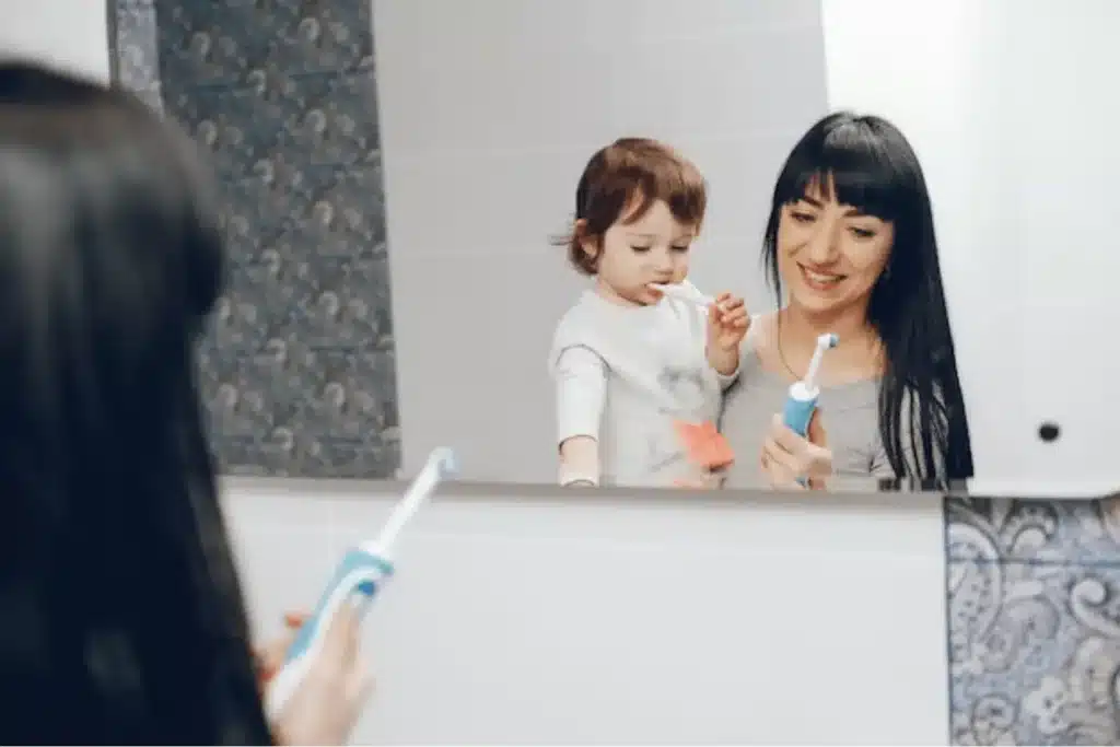 Image of a Mom and a kid are brushing their teeth