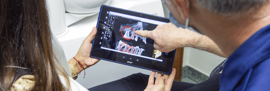 A man and a woman looking at a dental x-ray on a tablet computer.