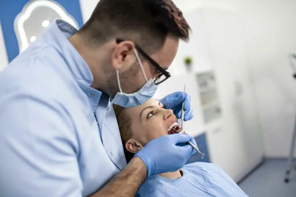 How to whiten your teeth fast. 13 Dentist examining patient's teeth during appointment.