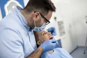 How to fix a cracked tooth. 1 Dentist examining patient's teeth during appointment.