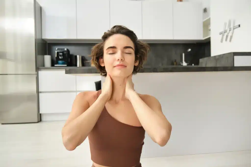 Woman doing stress management techniques to relax facial muscles.