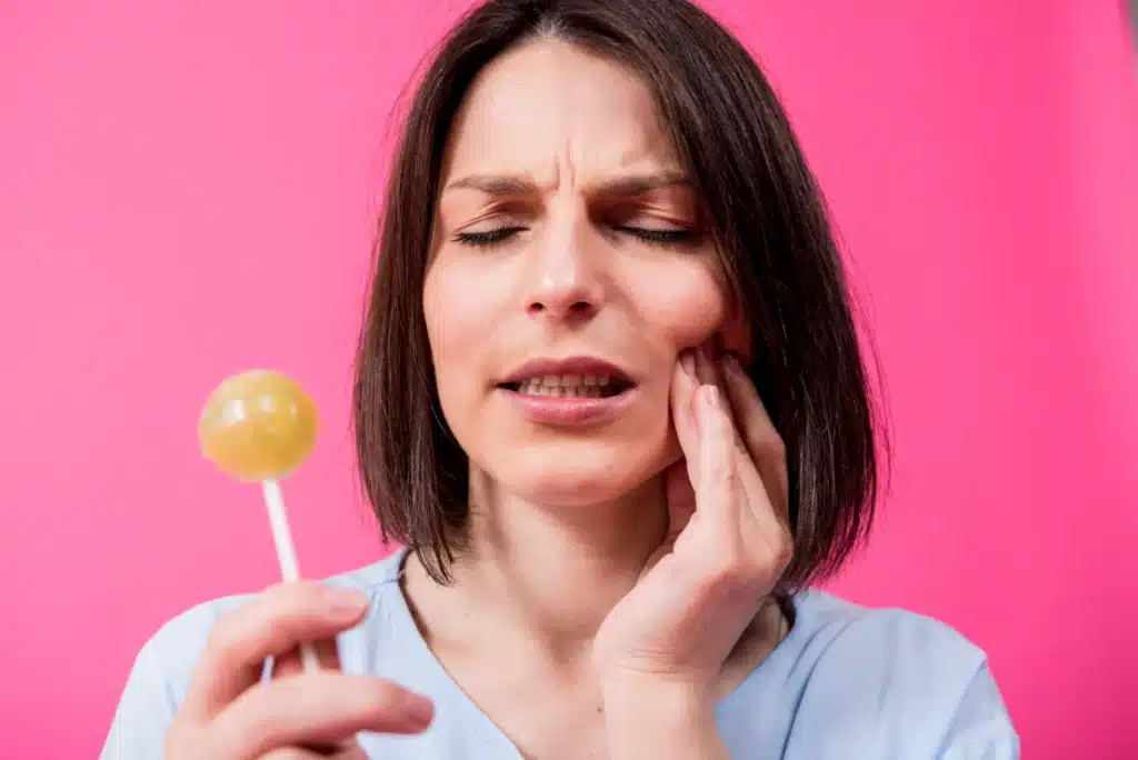 Woman with hard candy having jaw pain.