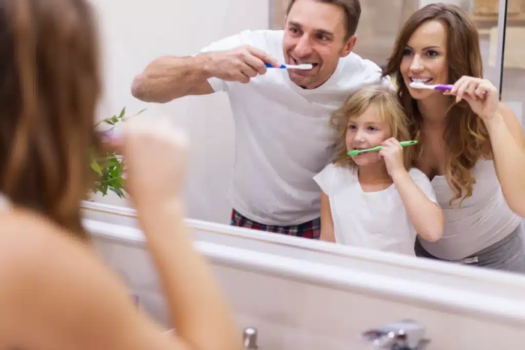 Family brushing teeth to prevent gum disease