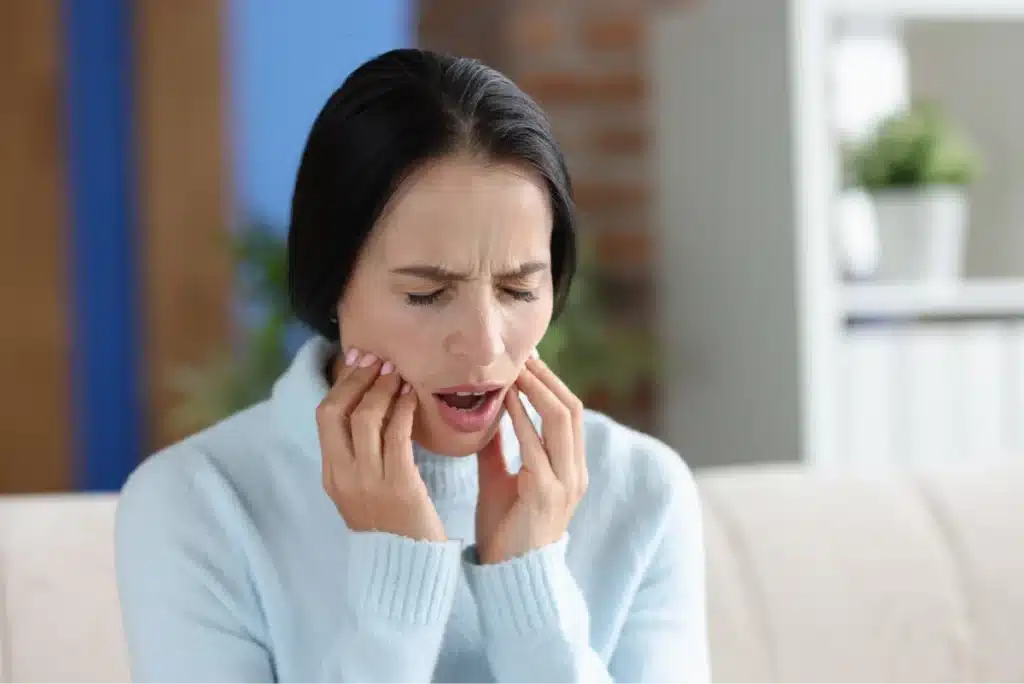 Woman with TMJ disorder having jaw pain.