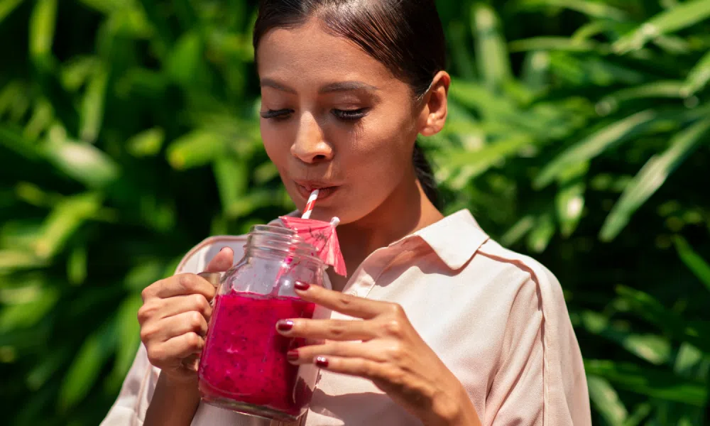 What Can You Eat with Braces? 2 Woman sipping a pink drink.