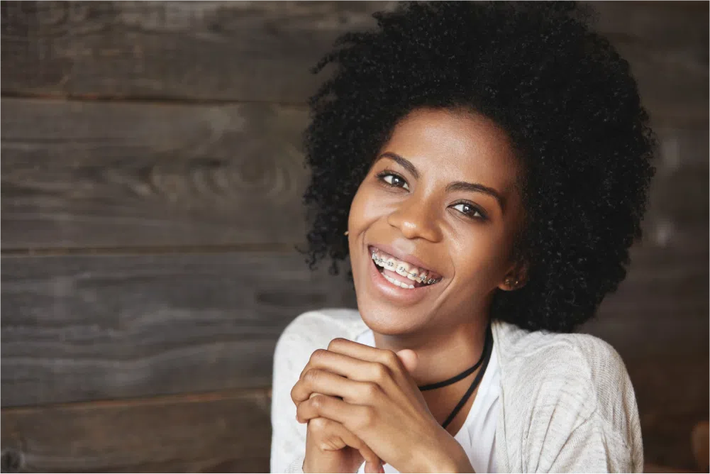 How Long Do You Have to Wear Braces? 1 Smiling woman with dental braces.