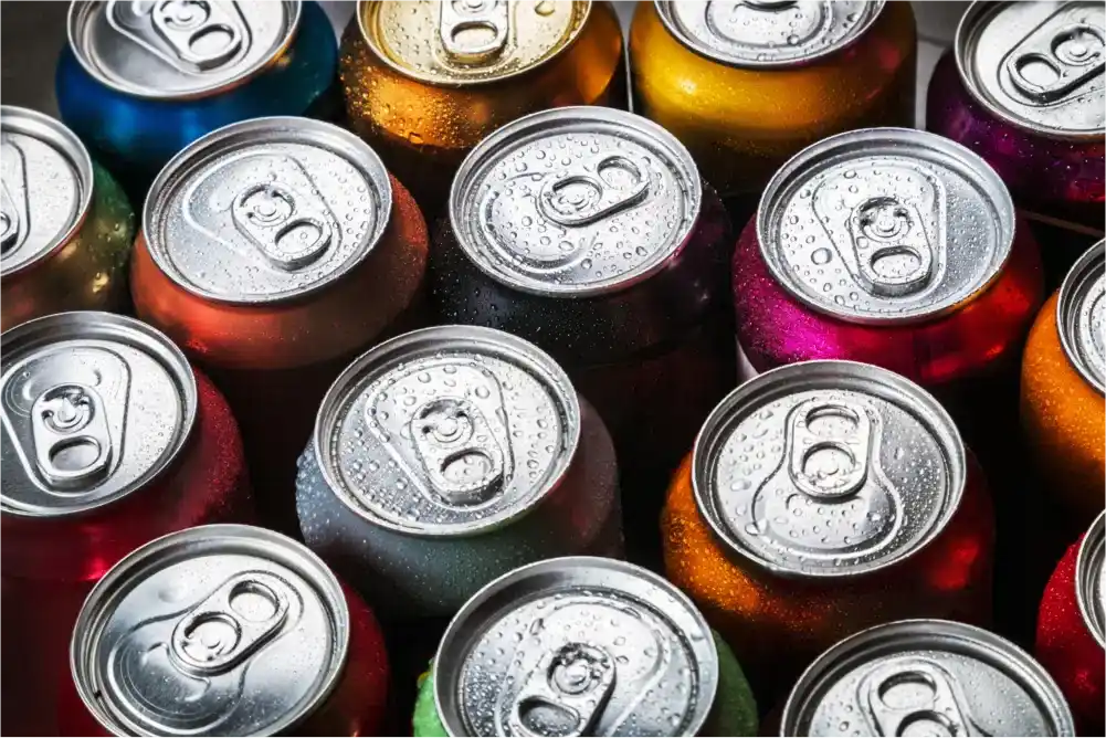 A close-up of colorful soda cans with water droplets.